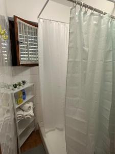 a shower with a white shower curtain in a bathroom at Holiday house“Tonka” in Žuljana
