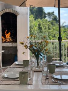 a table with plates and glasses and a fireplace at Holiday house“Tonka” in Žuljana