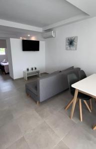 ein Wohnzimmer mit einem Sofa und einem Tisch in der Unterkunft Apartamentos Cristina in Cala Millor