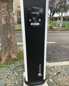 a black and white parking meter sitting next to a tree at Hotel Corsa in Mangalia