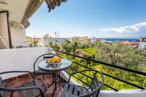 a balcony with a table and chairs and the ocean at Mani’s studios in Skala Sotiros