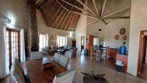 a living room with a wooden table and chairs at Izintaba Private Game Reserve Waterberg in Vaalwater