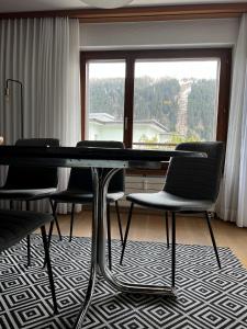 einen Tisch und Stühle in einem Zimmer mit Fenster in der Unterkunft 2.5 Zimmer Wohnung Davos Platz in Bolgen