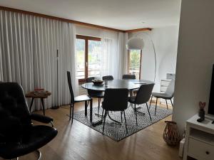 a living room with a dining room table and chairs at 2.5 Zimmer Wohnung Davos Platz in Bolgen