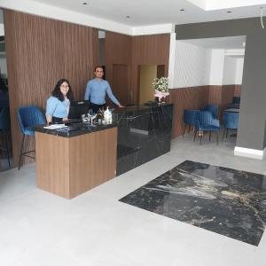 a man and woman standing at a counter in a lobby at ALESSIA HOTEL & SPA in Side