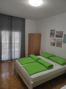 a bedroom with a large bed with green pillows at Apartment Ivano in Vodice