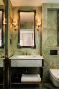 La salle de bains est pourvue d'un lavabo, d'un miroir et de toilettes. dans l'établissement The Serangoon House, Singapore, a Tribute Portfolio Hotel, à Singapour