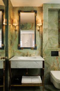 a bathroom with a sink and a mirror and a toilet at The Serangoon House, Singapore, a Tribute Portfolio Hotel in Singapore