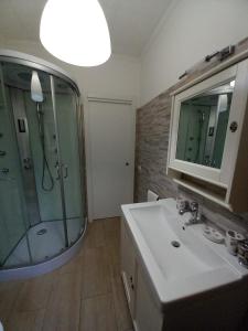 a bathroom with a shower and a sink and a mirror at Casa vacanze M&M Tortolì in Tortolì