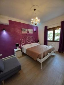 um quarto com uma cama e uma parede roxa em Casa vacanze M&M Tortolì em Tortolì