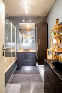 La salle de bains est pourvue d'un lavabo, d'une baignoire et d'un miroir. dans l'établissement Homestay in a nice flat, à Mondorf-les-Bains
