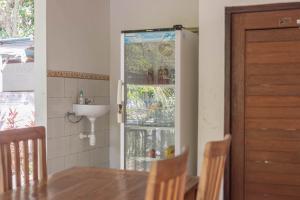 cocina con mesa y puerta de cristal en Nyuh Kadah Guest House en Nusa Penida