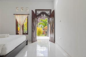 Un dormitorio con una cama y una ventana abierta. en Nyuh Kadah Guest House, en Nusa Penida