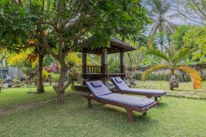 2 sillones y cenador en el jardín en Nyuh Kadah Guest House en Nusa Penida