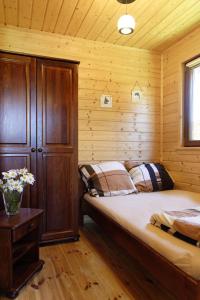 a bedroom with a bed in a wooden cabin at SOLAR WICIE in Wicie