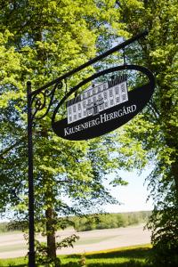 un letrero colgando de un poste en un parque en Krusenberg Herrgård, en Krusenberg