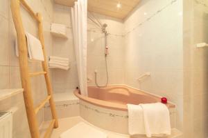 a bathroom with a tub and a shower with towels at Ganzes Haus mit großem Garten und eigener Sauna in Unterwössen +37 photos