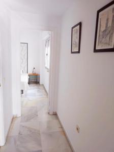 a hallway with white walls and a tile floor at Florencio Quintero Home in Seville