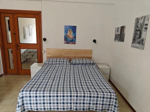 a bedroom with a bed with a checkered blanket at Casa in Centro in Fondi