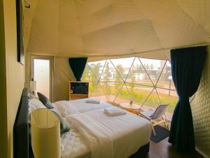 a bedroom with a bed and a large window at The Dome @ Gua Musang in Gua Musang