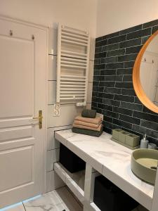 een badkamer met een wastafel en een spiegel bij Maison au bord de l'eau et au calme pour les vacances in Saint-Denis-de-Pile