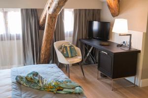 a bedroom with a bed and a desk with a television at Hotel Grande Italia in Chioggia