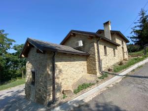 un pequeño edificio de piedra al lado de una carretera en Casa Tincana, en Bebbio