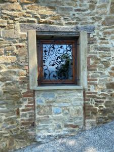 een raam op een stenen muur met een plant erin bij Casa Tincana in Bebbio