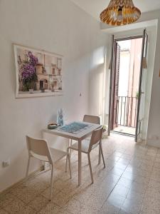 a dining room with a white table and chairs at Casa in Centro in Fondi +7 photos