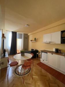 een keuken en een woonkamer met een tafel en stoelen bij Apartment Hotel Marchesini in Ravenna