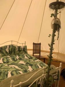 a bedroom with a bed with a plant next to it at Camping By The River 