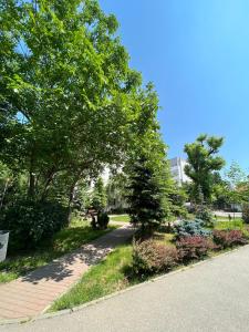 a park with trees and flowers on the side of a road at Apartamentul Oaspetilor in Slatina