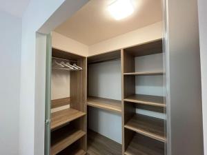 a walk in closet with wooden shelves and a light at Swan Apartman - Keszthely in Keszthely