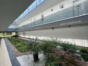 a building with a walkway and a courtyard with plants at Swan Apartman - Keszthely in Keszthely
