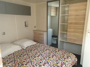 a small bedroom with a bed and a closet at Camping Pré Vologne in Granges-sur-Vologne