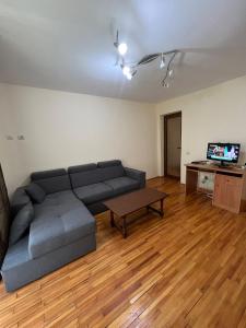 uma sala de estar com um sofá e uma mesa em Apartamentul Oaspetilor em Slatina