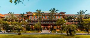 a large building with palm trees in front of it at Puerto Antilla Grand Hotel in Islantilla