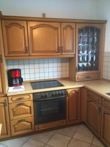 a kitchen with wooden cabinets and a stove top oven at Ferienapartment Kleist in Prerow +5 photos