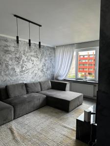 a living room with a couch and a window at Hugo in Jēkabpils