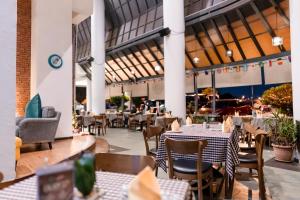 un restaurant avec des tables et des chaises dans un bâtiment dans l'établissement MITC Hotel, à Malacca