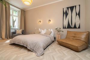Un dormitorio con una cama grande y una silla. en Arbio I Artsy Berlin Oasis Apartment, en Berlín 25 fotos más
