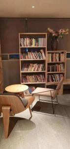 a library with two chairs and a table and books at Guangzhou Shug Art Hotel in Guangzhou