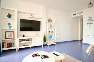 Televízia a/alebo spoločenská miestnosť v ubytovaní Xposure beach apartment