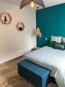 ein Schlafzimmer mit einem großen Bett mit blauer Wand in der Unterkunft Escale au cœur du Vignoble Champenois in Mardeuil