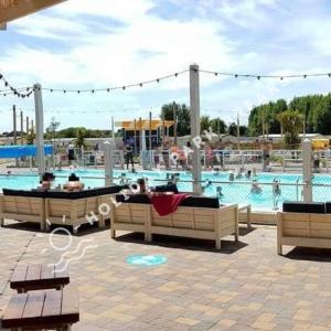 uma grande piscina com mesas e bancos num parque em Marlow - Gold 2 bed with veranda and parking at Seal Bay Resort em Selsey