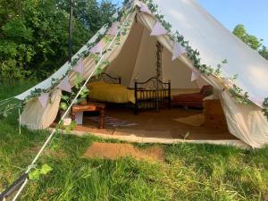 Tienda con cama en medio de un campo en Camping By The River 