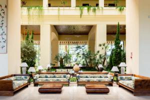 a lobby with couches and tables in a building at Puerto Antilla Grand Hotel in Islantilla