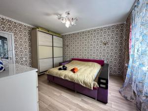 1 dormitorio con 1 cama de color púrpura en una habitación en LUZ @ Chisinau, en Chişinău 12 fotos más