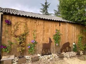 due animali dipinti sul lato di una recinzione di legno di Chalet 2 pers « chez Jojo » a Sérignac