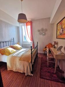 1 dormitorio con cama, mesa y escritorio en 'Quelle Belle Vue' Chambre d'Hote, en Confolens